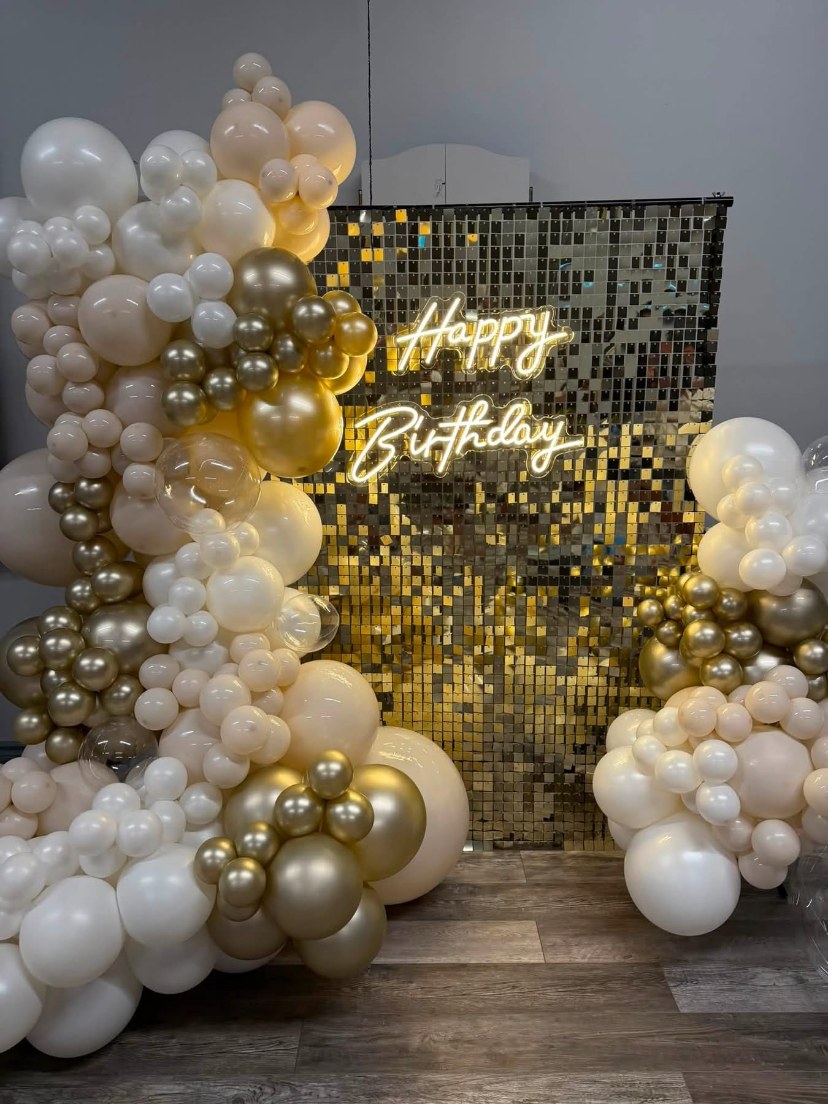 White and gold balloons framing a birthday shimmer wall
